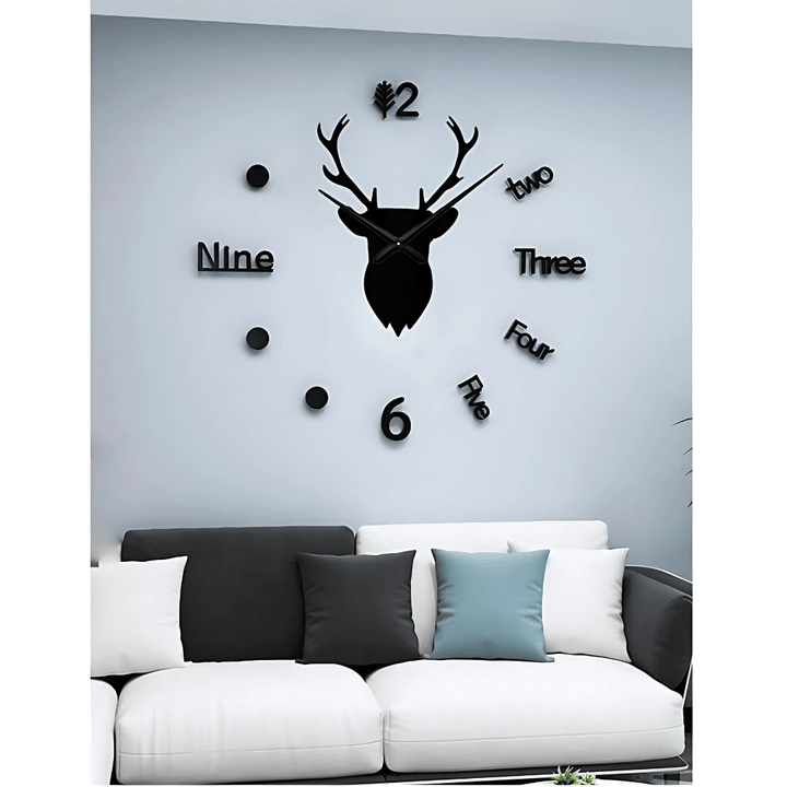 Black deer head wall clock with numbers on a gray wall above a white sofa.